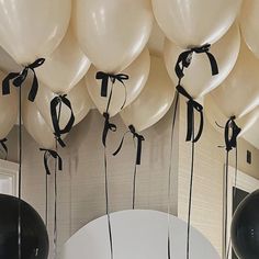 balloons are tied to the ceiling with black ribbons