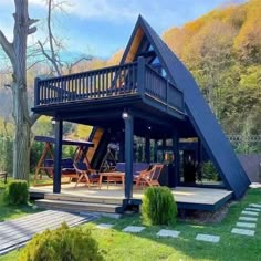 a house that has a large deck in front of it and stairs leading up to the roof