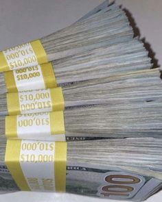 stacks of $ 10, 000 dollars are stacked on top of each other with yellow ribbons