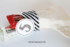 a candy bar wrapped in white paper with a black and white striped tie