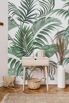 a living room with a palm leaf wallpaper and wooden table in front of it