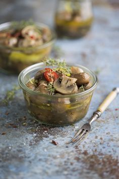 two small glass bowls filled with food on top of a table