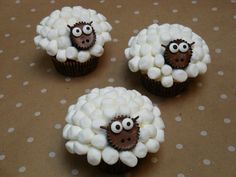 three cupcakes decorated like sheep with googly eyes