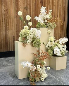 three vases with flowers are sitting on the ground