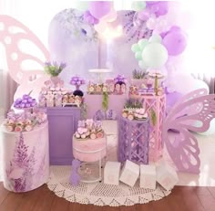 a purple and white dessert table with lots of cupcakes