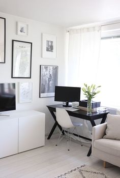 a living room with white furniture and pictures on the wall above it's desk