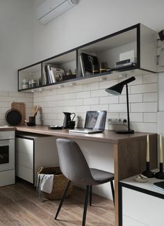 a desk with a laptop on top of it next to a shelf filled with books