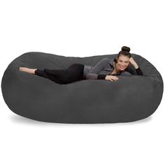 a woman laying on top of a large bean bag chair