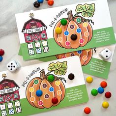 two game cards with buttons and candy on the table next to them are diced pumpkins