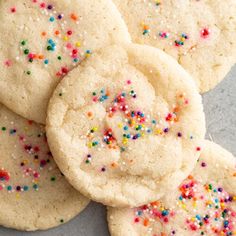 white sugar cookies with colorful sprinkles on a gray table top, ready to be eaten