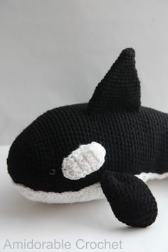 a crocheted black and white orca whale stuffed animal on a white background