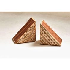 two pieces of wood sitting next to each other on a white surface with one piece missing