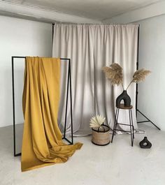 an empty room with two vases and a yellow cloth draped over the floor in front of it