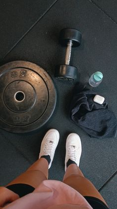 the person is sitting on the floor with their feet up next to a dumbbell