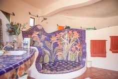 a bath room with a toilet and a sink next to towels hanging on the wall