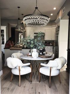 a dining room table with two chairs and a chandelier