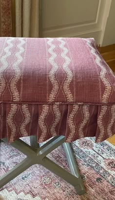 a footstool sitting on top of a rug covered floor