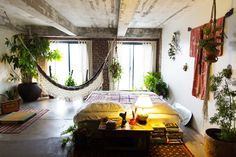 a bedroom with a hammock hanging from the ceiling and plants on the wall