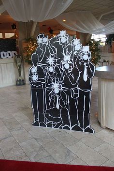 a black and white cutout of two men in front of a bar with christmas decorations