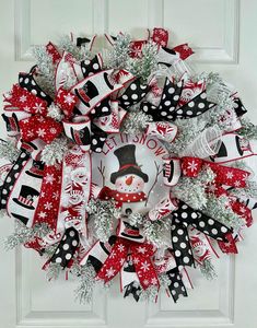 a red and white christmas wreath with snowman on the front, black and white polka dots