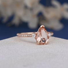 a ring with an oval cut peach sapphire surrounded by diamonds