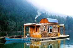 a small house boat floating on top of a lake