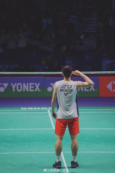 a man standing on top of a tennis court holding a racquet in his hand