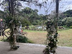 an outdoor ceremony setup with flowers and greenery on the ground, surrounded by trees