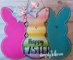 two easter bunnies hanging on a wooden wall with the words happy easter next to them