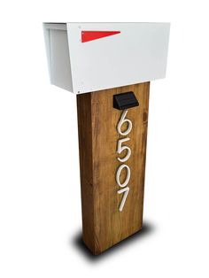 a white and red mailbox sitting on top of a wooden box