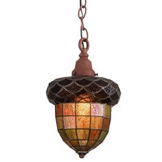 a light fixture hanging from a chain on a white wall with a stained glass shade