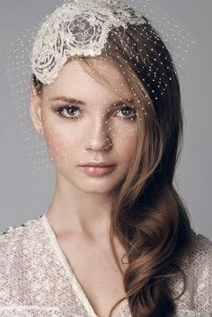 a woman wearing a veil and headpiece with pearls on it's head,