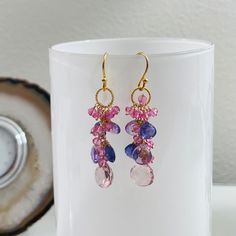 This is the last of three pairs in this color combination. This is a variation of my waterfall earrings. Instead of individual chandelier pendants, these gemstones are assembled in a lovely cluster cascading from the circle. These beautiful earrings consists of some of the most gorgeous amethyst, tanzanite, mystic pink quartz and mystic pink topaz. All of these gemstones are high quality and their remarkable sparkle and glow attest to it. The focal pink quartz measures approximately 10 mm all ar Amethyst Multi-stone Briolette Earrings, Briolette Gemstone Chandelier Earrings As Gift, Waterfall Earrings, Pink Topaz, Paper Jewelry, Matching Jewelry, Earrings In Gold, Cluster Earrings, The Circle