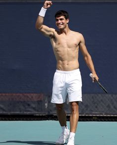 a shirtless tennis player waves to the crowd