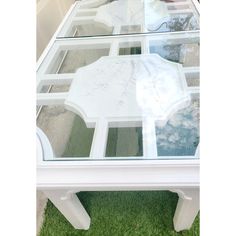 a white table with glass top on grass