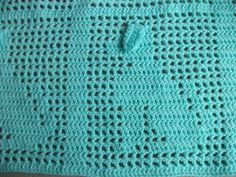 a blue crocheted bag sitting on top of a table