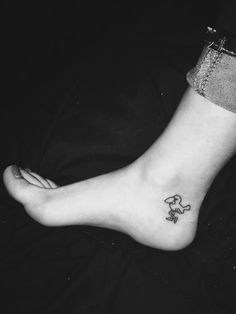 a woman's foot with a small dog tattoo on the side of her leg