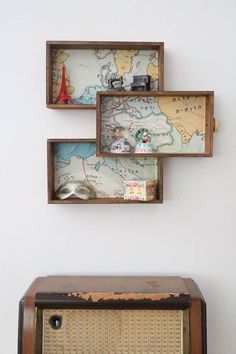 an old radio sitting on top of a wooden table next to a wall mounted map