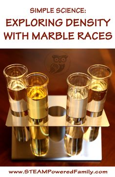 four glasses filled with liquid sitting on top of a metal tray that reads, simple science exploring density with marble races