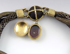 Presented is an incredible quality, antique, 14 karat yellow gold bead and human hair locket bracelet made during the mid 1800s, most likely around the 1840s. This Victorian necklace is a piece of mourning or memorial jewelry, finely hand weaved with the hair of a recently deceased loved one. The bracelet is large and slips over the wrist easily. The bracelet is comprised of both woven hair and has 14 karat yellow gold, hand engraved accents and a locket. The locket snaps securely shut and the b Victorian Brown Collectible Jewelry, Victorian Style Brown Collectible Jewelry, Brown Oval Victorian Jewelry, Victorian Oval Brown Jewelry, Victorian Brown Oval Jewelry, Victorian Style Oval Brown Jewelry, Hair Locket, Fish Pendant Necklace, Jelly Opal