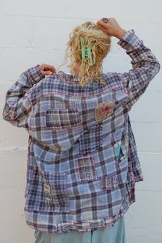 a woman standing in front of a white brick wall with her hands on her head