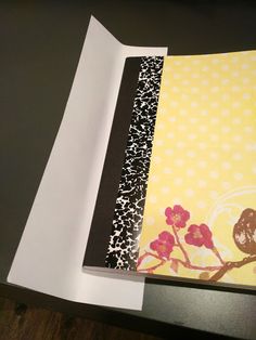 an open book on a table with flowers and polka dot paper in the pages,