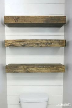 three wooden shelves above a toilet in a bathroom