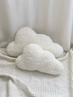 a white teddy bear laying on top of a bed next to a pillow and blanket