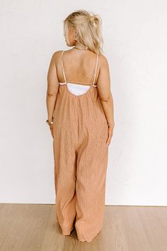 - Stay stylish in this trendy jumpsuit! - Unlined pleated material - A v-cut neckline - Adjustable spaghetti straps - A back with elastic detail - Hidden side pockets - A relaxed silhouette that ends in straight ankle length hemlines Measurements 1XL : Bust 38", Hip 50", Inseam 26", Int Width 22.5", Length 51", Torso 22.5", Waist 44". 2XL : Bust 40", Hip 52", Inseam 26.5", Int Width 23", Length 51", Torso 23", Waist 46". 3XL : Bust 42", Hip 54", Inseam 27", Int Width 23.5", Length 51.5", Torso 2 Vacation Jumpsuits And Rompers With Spaghetti Straps And Pockets, Vacation Jumpsuits With Spaghetti Straps And Pockets, Beach Jumpsuits And Rompers With Spaghetti Straps And Pockets, Beige Jumpsuits And Rompers With Pockets For Beach, V-neck Brown Jumpsuits And Rompers For Beach, Summer Brown Jumpsuits And Rompers For Vacation, Beige Beach Jumpsuits And Rompers With Pockets, Vacation Jumpsuit With Smocked Back And Spaghetti Straps, Beach V-neck Jumpsuits And Rompers With Smocked Back