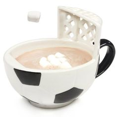 a cup of hot chocolate with marshmallows in the shape of a soccer ball