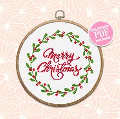 a cross stitch christmas ornament on a pink background with the text merry christmas