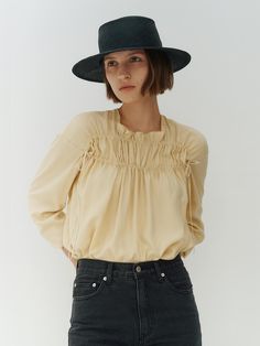 This is REMPLACEMENT’s blouse features a cool and soft touch with shirring as the focal point. The double lines of shirring create an elegant shoulder line and allow for additional shirring to be adjusted according to individual body shapes. - Ideal for daily wear- Can be paired with various bottoms for versatile styling- Japanese directly imported double-sided velvet ribbon, dyed to match the fabric color, adds a detailed touch Spring Workwear Blouse With Smocked Bodice, Elegant Summer Blouse With Smocked Back, Chic Blouse For Gatherings, Chic Blouse With Smocked Back And Billowy Fit, Chic Billowy Blouse With Smocked Back, Chic Daywear Blouse With Smocked Back, Chic Billowy Top With Smocked Back, Chic Billowy Tops With Smocked Back, Spring Billowy Blouse For Gatherings