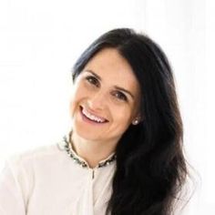 a woman with long black hair smiling at the camera