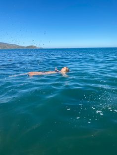 a man swimming in the ocean with his head above the water